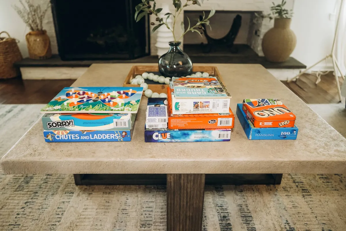 A close-up of a coffee table set up for board games, complete with a decorative vase and comfortable seating. The mood is intimate and playful, setting the stage for classic game nights and shared laughter among guests.